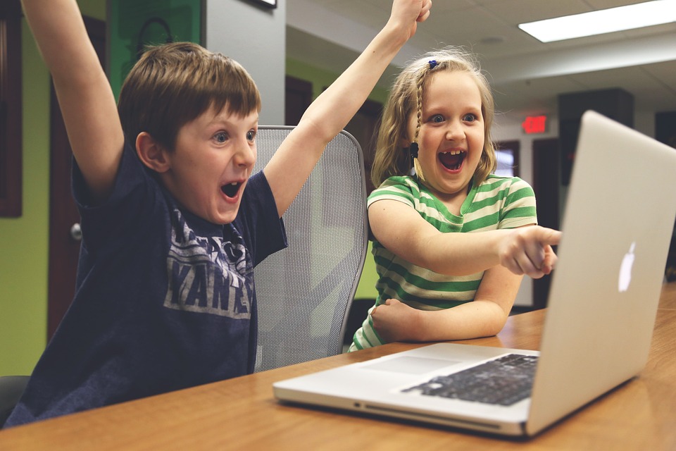 Image of kids using computer, celebrating having a managed service provider (MSP)