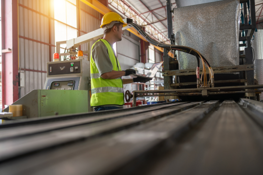 Manufacturing professional using a laptop on a production line with In-Telecom technology solutions for smart manufacturing operations